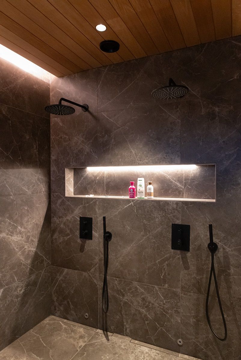 Belysningen i duschrummet består av en LED-list med taklist, en LED-list med schamposlang och infällda takspotlights.
